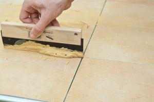 Grouting floor tiles