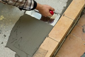 Spreading tile adhesive with trowel Spreading tile adhesive with trowel