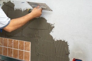 Spreading adhesive on concrete wall Spreading adhesive on concrete wall